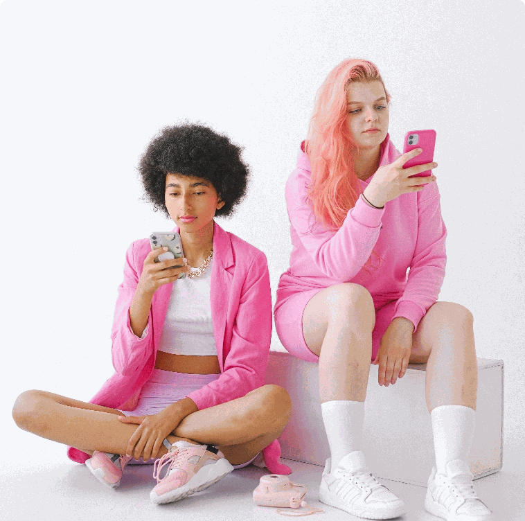 Two young women scrolling on their phones, the kind of audience reached through social and video ads