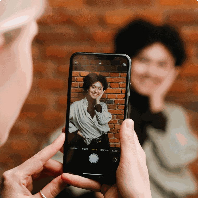 Phone camera capturing a smiling model against a brick wall during a content shoot for Facebook ads Malaysia campaigns